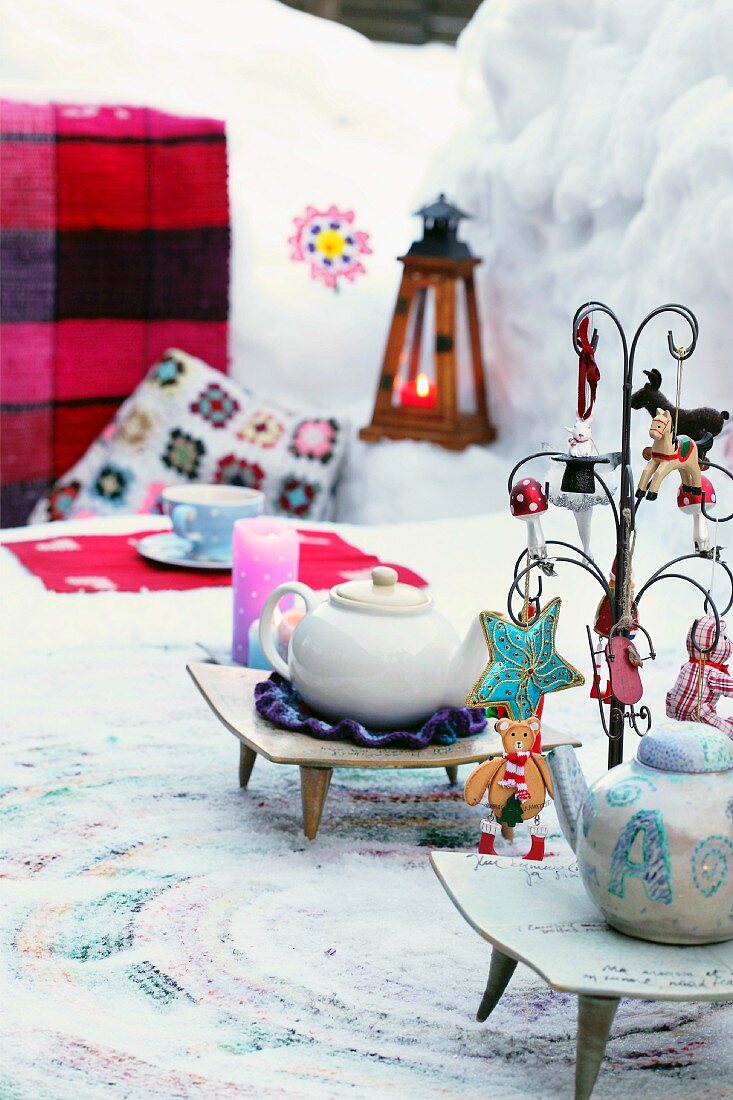 Teekannen auf gedecktem und geschmücktem Tisch im Freien bei winterlicher Stimmung