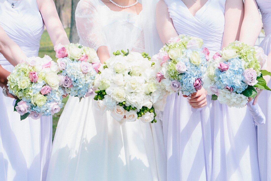 Braut und Brautjungfern ganz in Weiß mit prächtigen Blumenbouquets