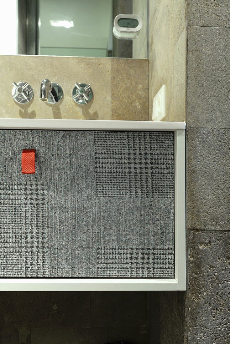 Drawer with houndstooth pattern on grey front below sink