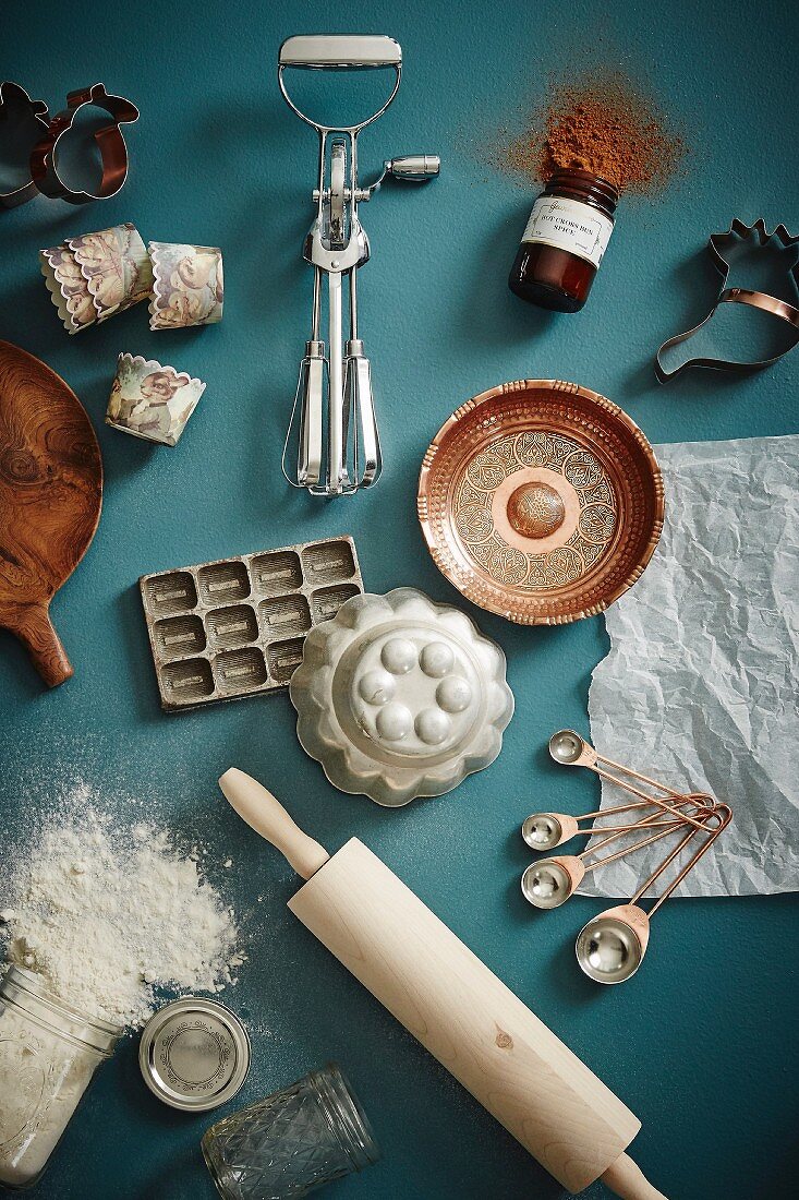 Vintage baking and kitchen utensils on a petrol colored surface
