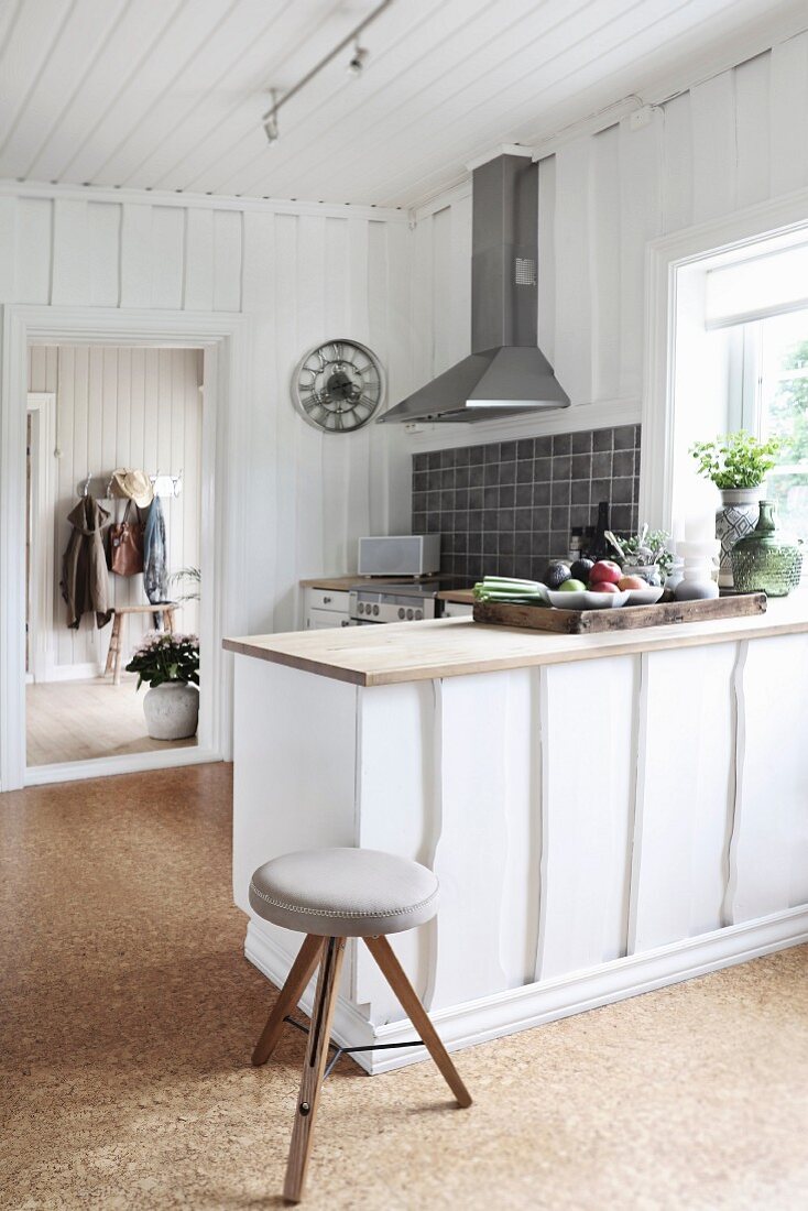 Küchentheke und Hocker in Landhausküche mit weisser Holzverschalung und Korkboden