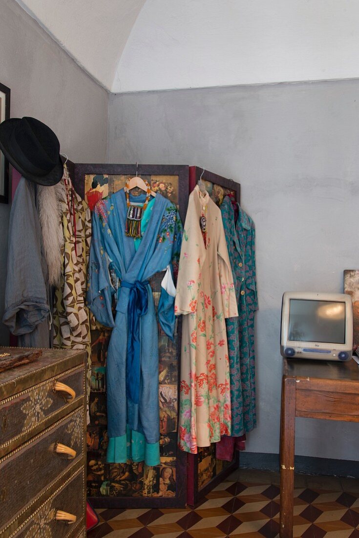 Auf Paravent gehängte Kimonos in Schlafzimmerecke mit Segmentbogen