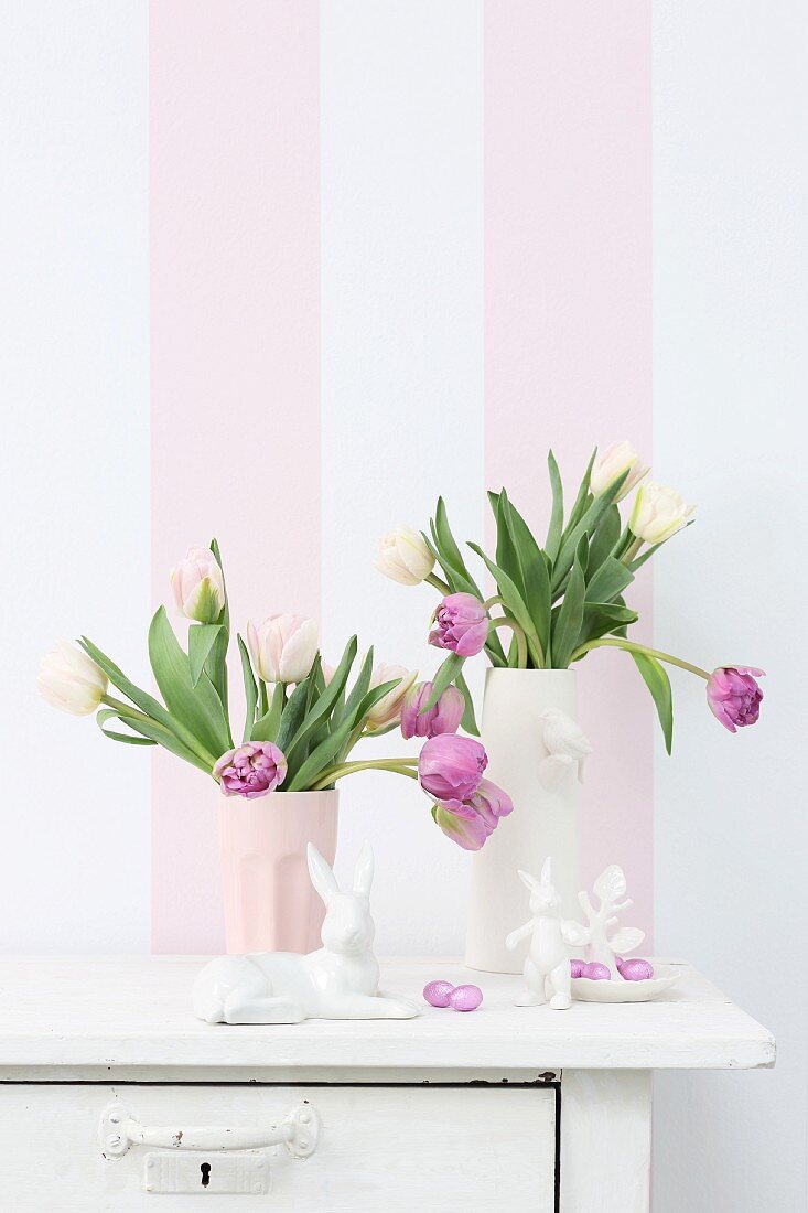 China Easter bunnies and vases of tulips in front of striped wallpaper