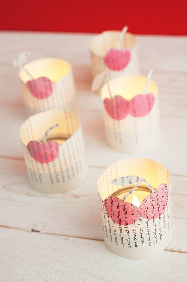 Romantische Teelichter mit ausgeschnittenen Buchseiten und bemaltem Kirschenmotiv