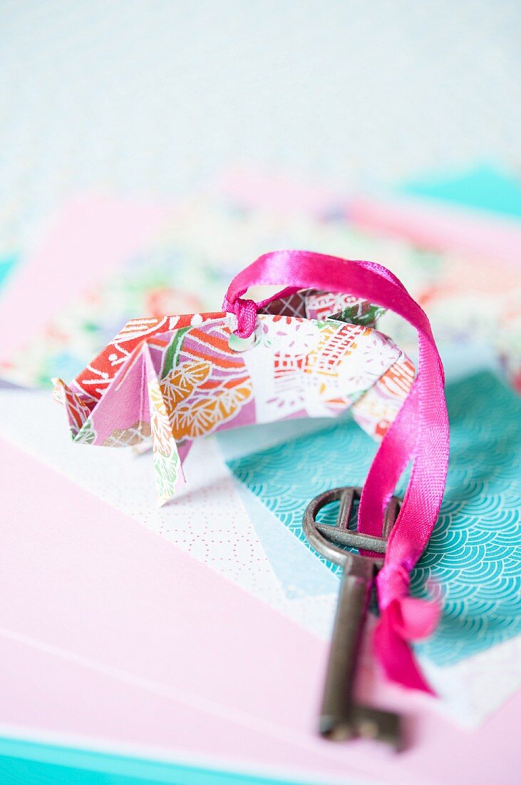 Schlüsselanhänger aus buntem Origamipapier mit pinkfarbenem Geschenkband