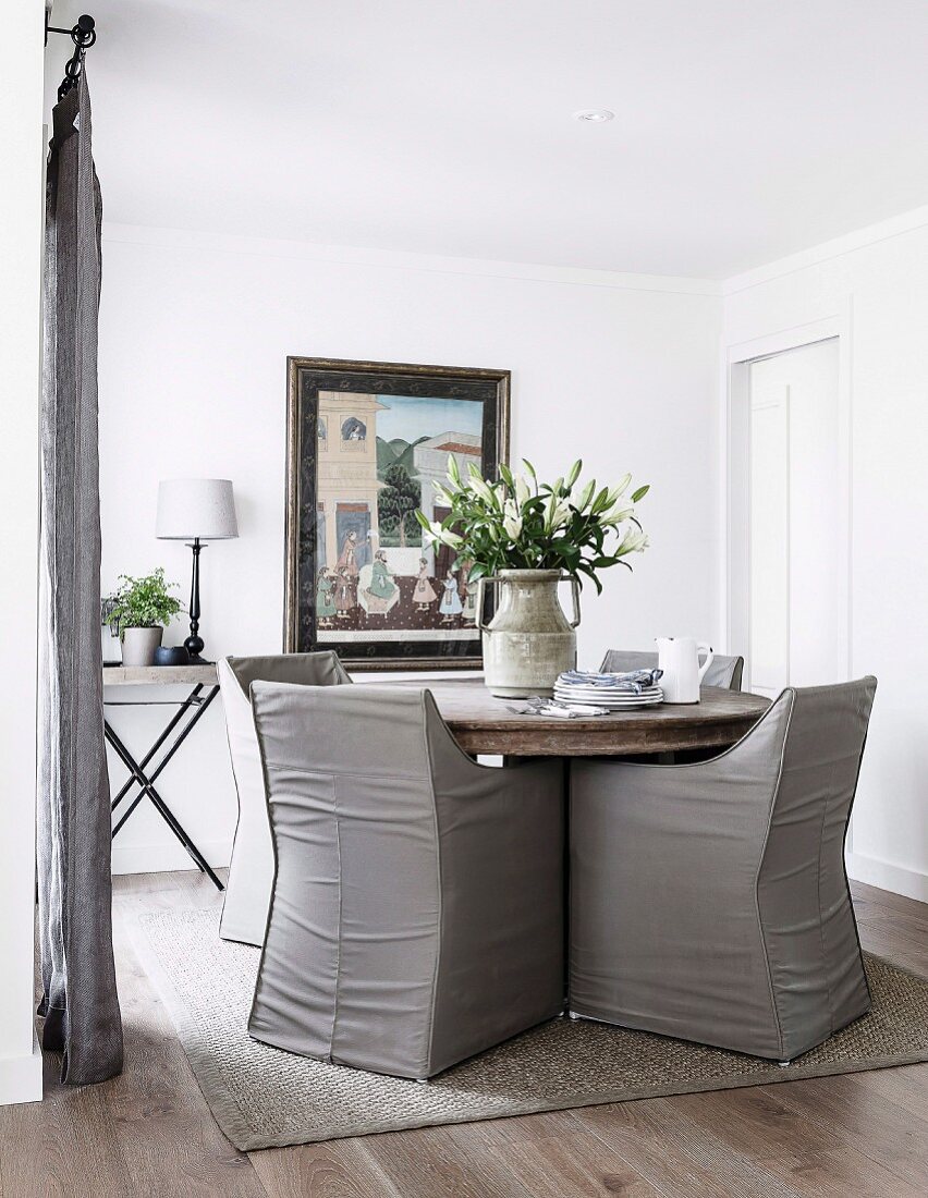 Round table with gray leather armchairs in the dining room