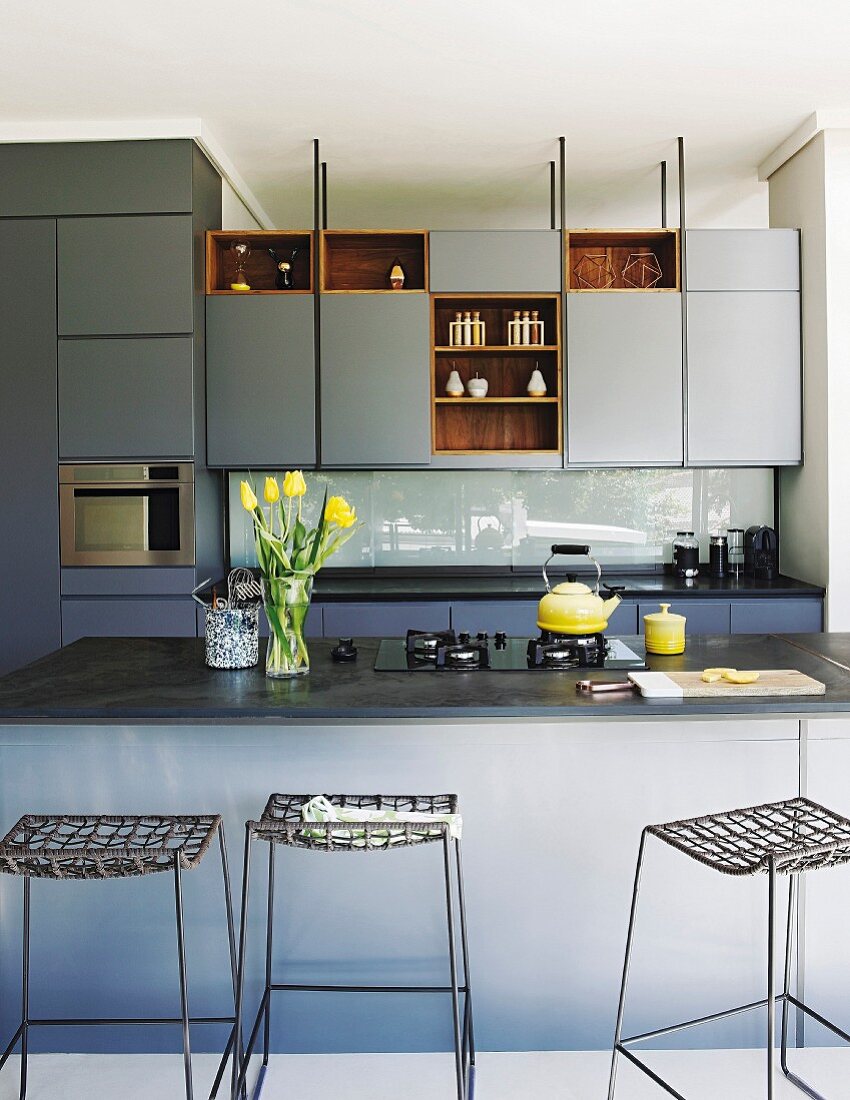 Elegante, blaugraue Einbauküche mit Küchentheke und Barhockern