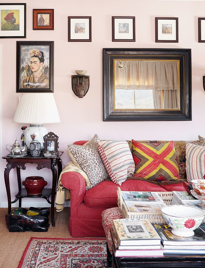 Red sofa, antique side table and gallery of pictures in living area