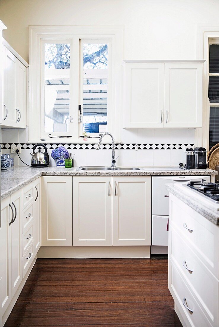 White corner country kitchen with black and white border under wall cupboards