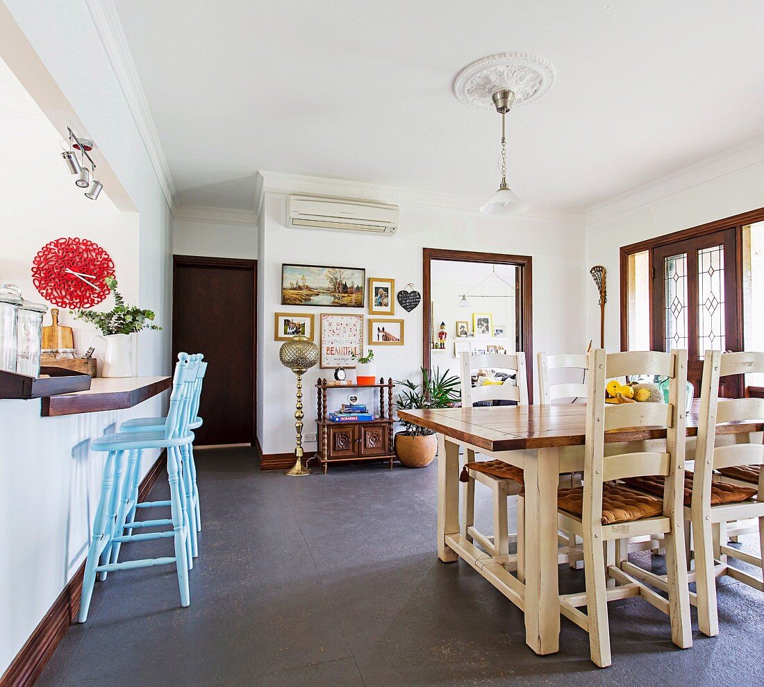 Essbereich im ländlichen Stil, hellblaue Barhocker an Küchentheke mit roter Wanduhr