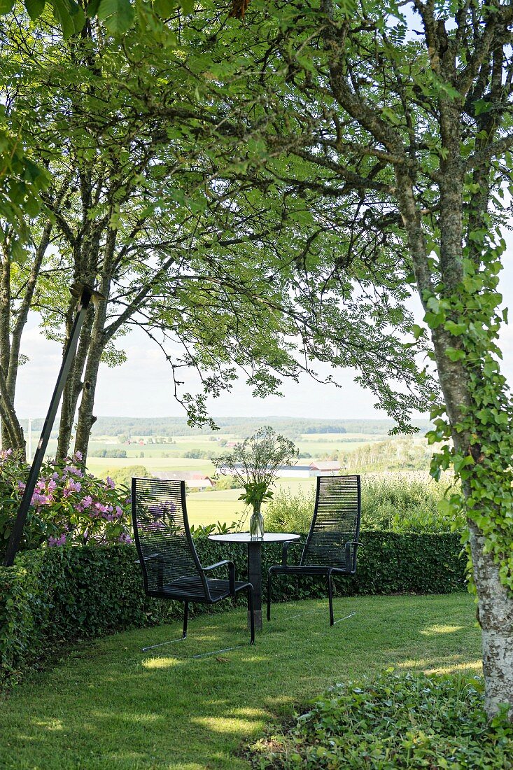 Seating area in idyllic summer garden with view of landscape