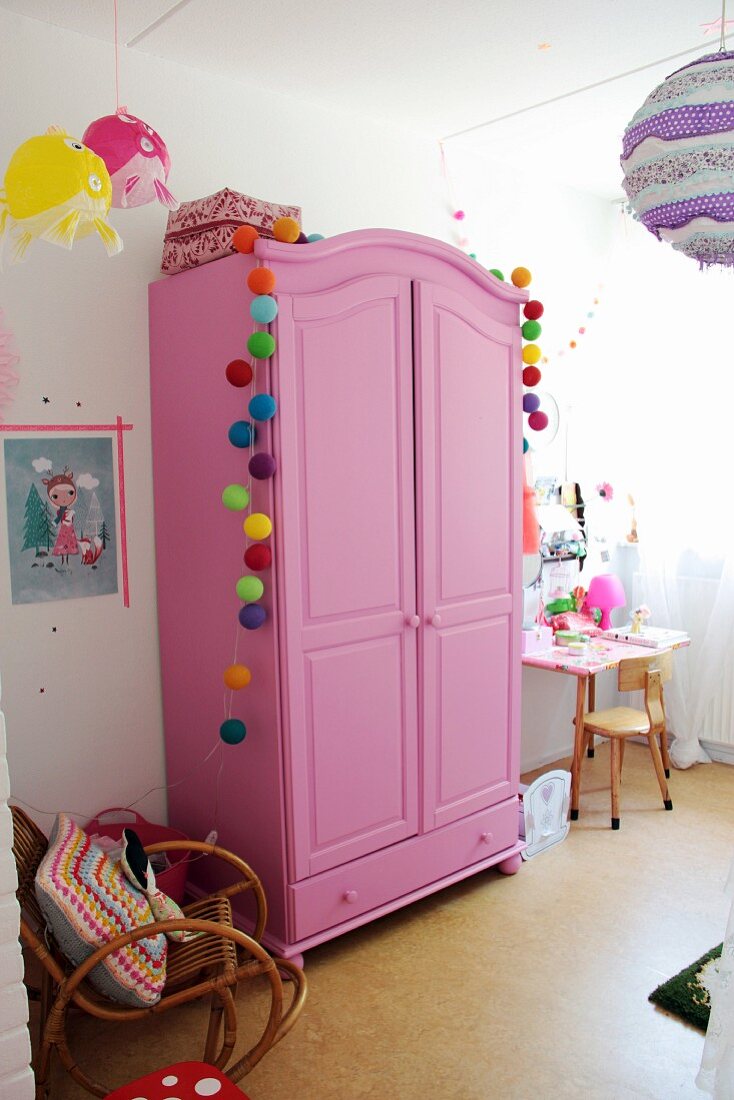 Pinkfarbener Kleiderschrank mit bunten  – Bild kaufen – 16