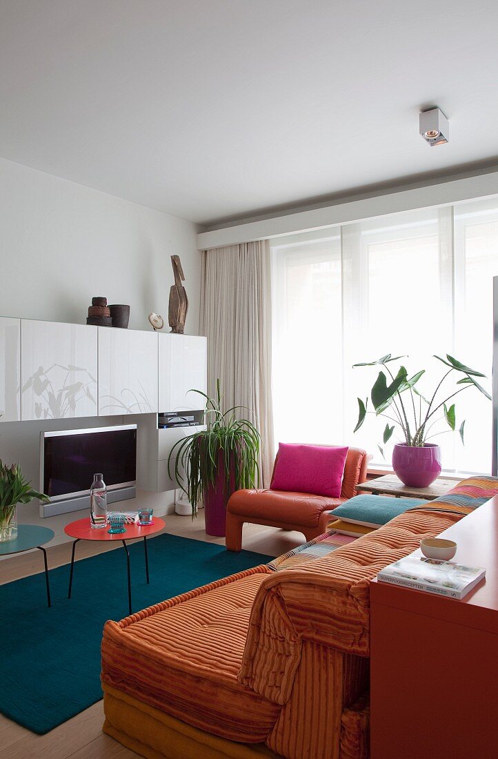 White furniture and colourful home textiles in small living room