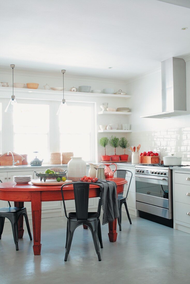 Roter Esstisch und Metallstühle in der Küche