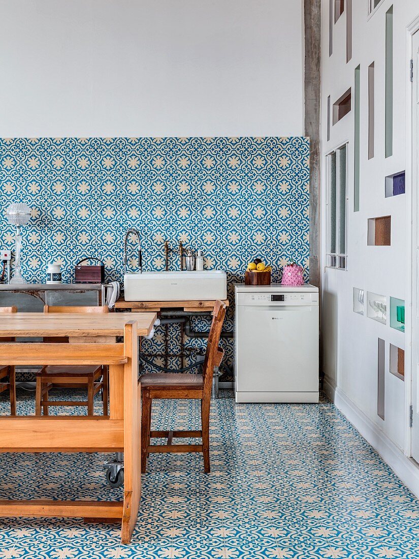 Küche in Loft mit blau-weissen Ornamentfliesen auf Boden und Wand