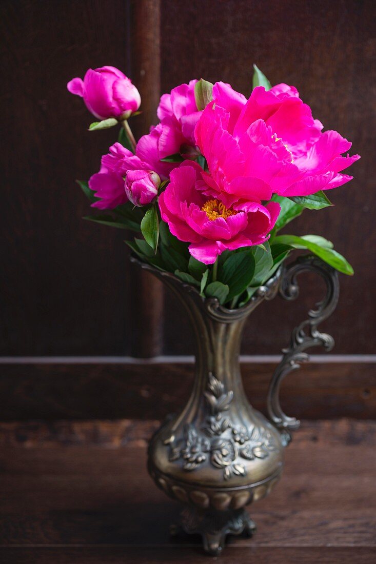 Pink peonies in antique metal vase