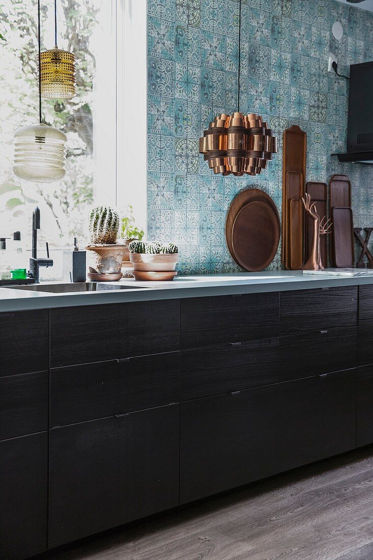 Kitchen counter below window and blue patterned wall tiles