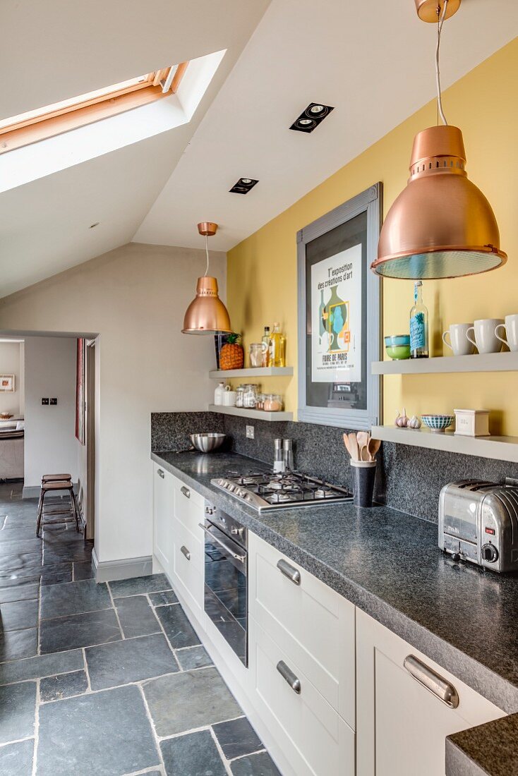 Küchenzeile mit Granit Arbeitsplatte und Wandboards an gelber Wand