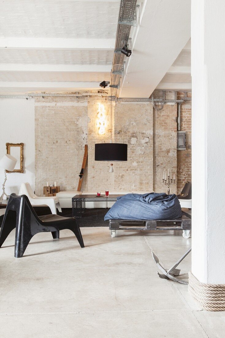 Lounge in Loftwohnung im Industriestil mit Ziegelwand und Betonboden