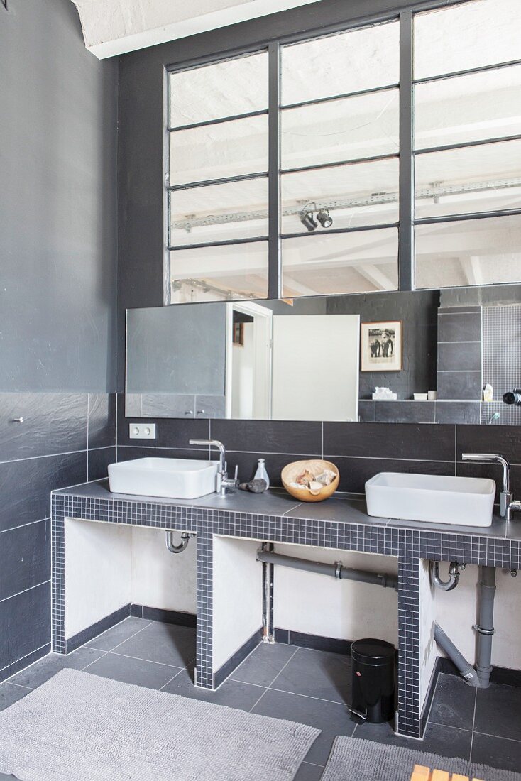 Minimalistisches Bad mit zwei Aufsatzbecken in Loftwohnung mit Industrieverglasung