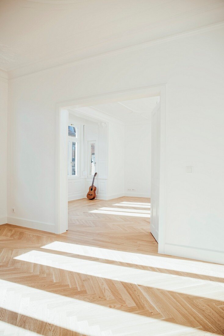 Gitarre lehnt an der Wand in leerer Altbauwohnung