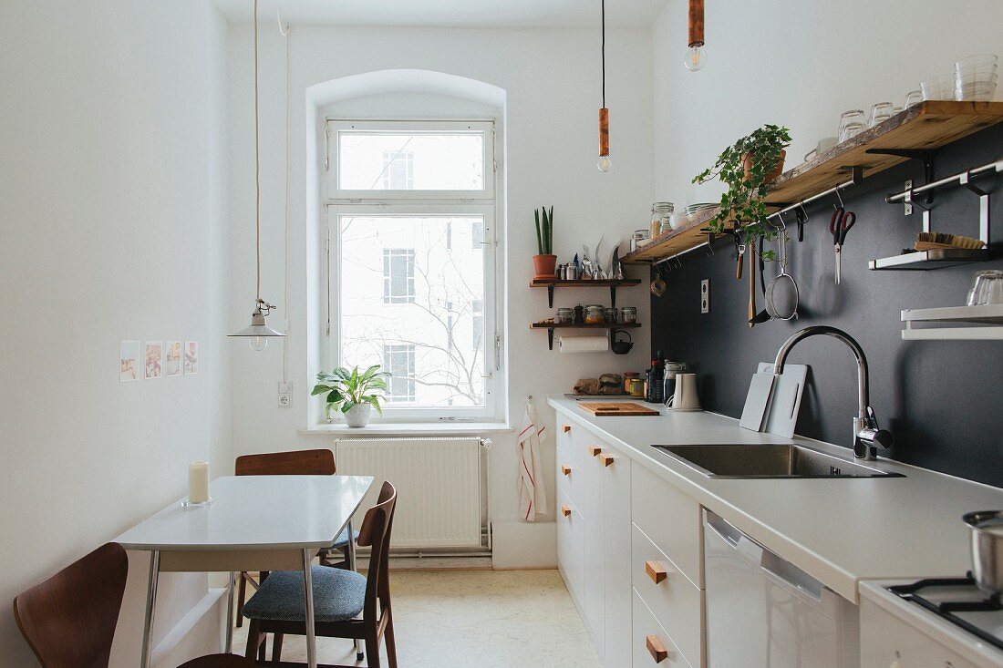 Schmale Küche mit zweifarbiger Wand und Essplatz