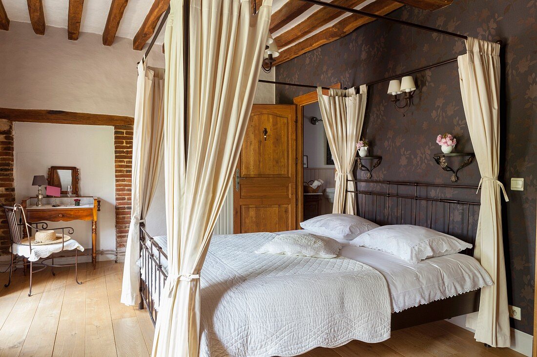 Nostalgisches Schlafzimmer mit Himmelbett, geschmückten Wandkonsolen und Schminktisch