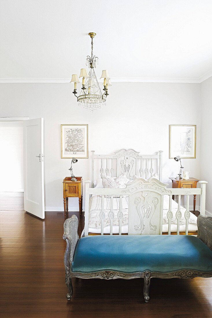 Antikes, weiss gestrichenes Holzbett, davor Rokoko Kleiderbank im Schlafzimmer