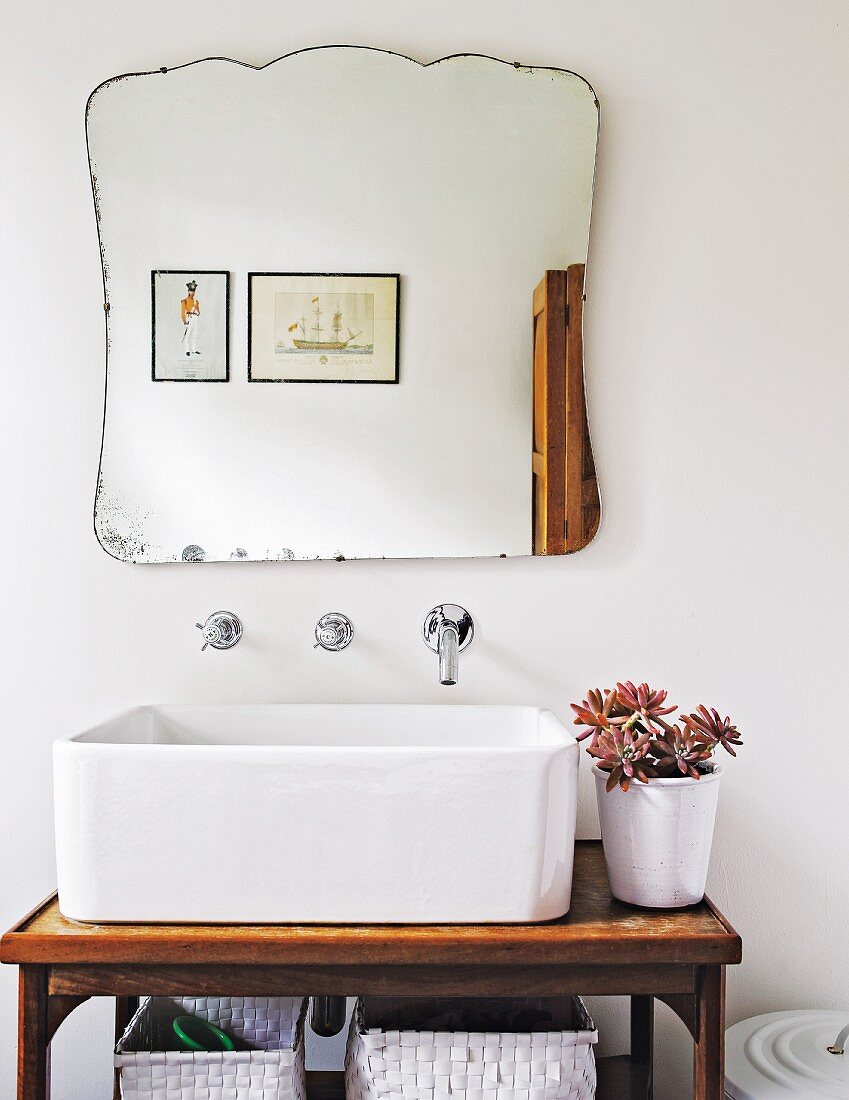 Vintage-style mirror with scalloped edges above square sink