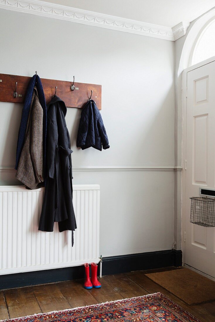 Coat rack made from old plank in hallway with dado rail and stucco frieze