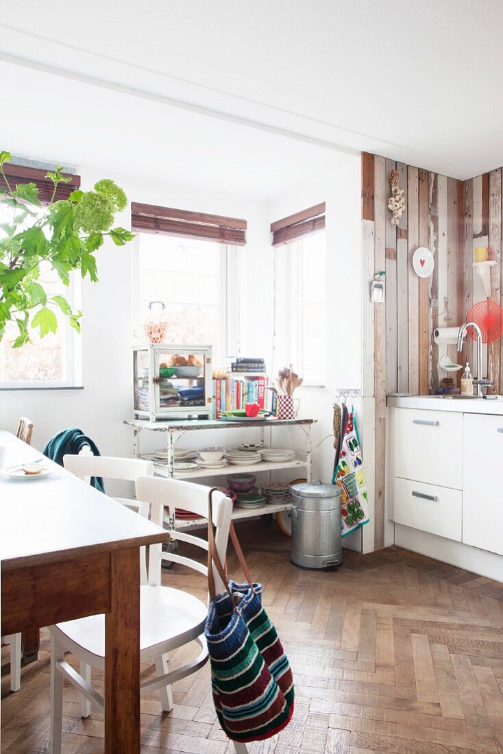 Wood cladding and herringbone parquet floor in retro kitchen-dining room
