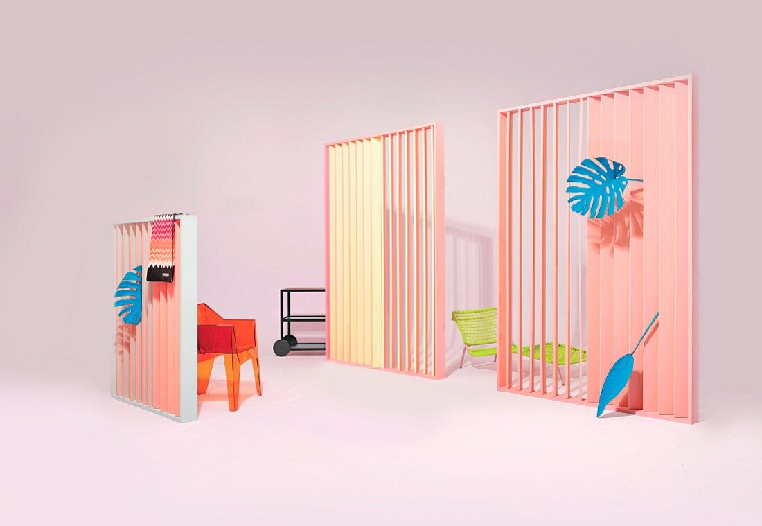 An arrangement of various garden furniture, a neon coloured garden shower and accessories in a pastel coloured studio
