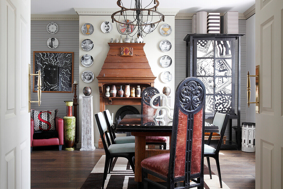 Striped wallpaper and decorative, designer wall plates in artistic dining room