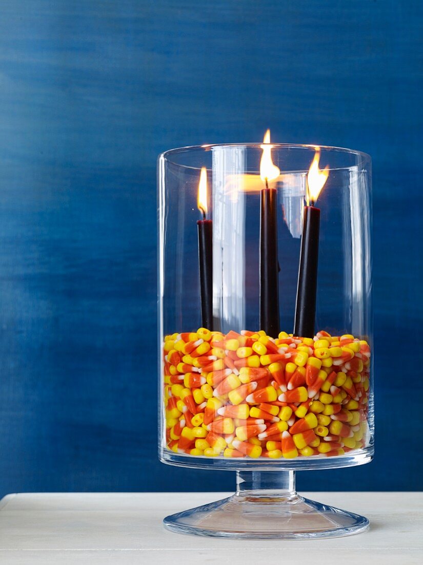 Halloweendekoration: Glasgefäss gefüllt mit Candy Corn als Windlicht für Kerzen
