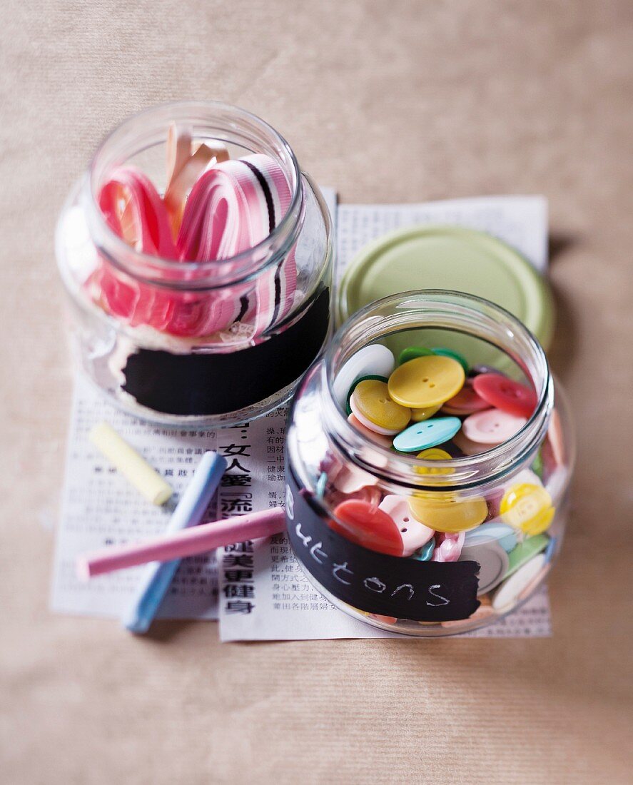 Buttons and ribbons in screw-top jars with chalkboard-paint labels