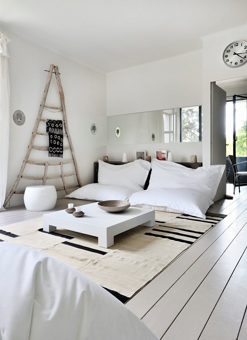 Gemütlicher Loungebereich mit weißen Sitzsäcken, Bodentisch und rustikalem Holzgestell