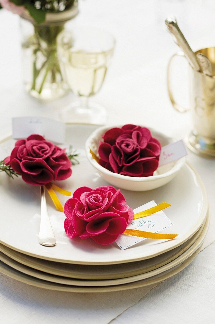 Place setting decorated with red roses and name tag for garden party