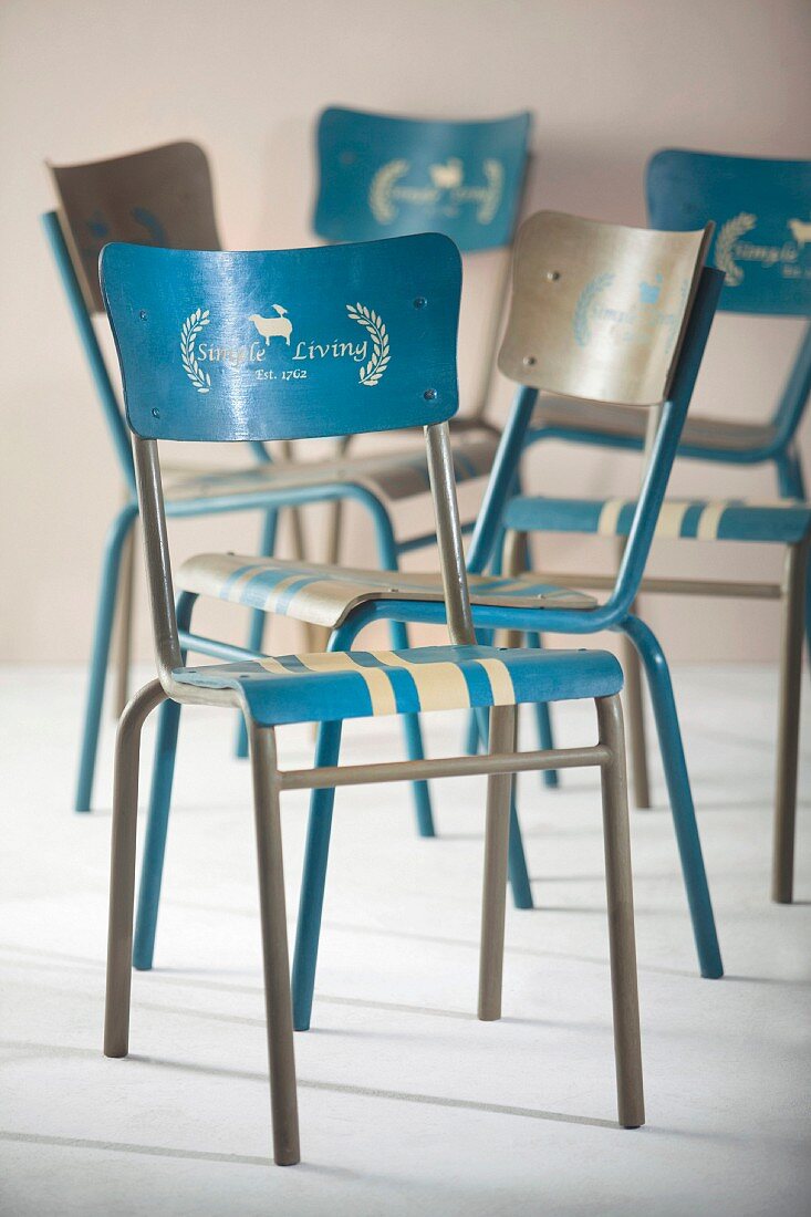 Blau-weiße Metallstühle mit Schablonentechnik beschriftet und lackiert