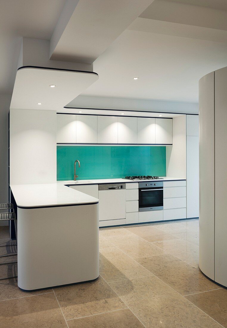 Projecting counter and blue splashback in white designer kitchen
