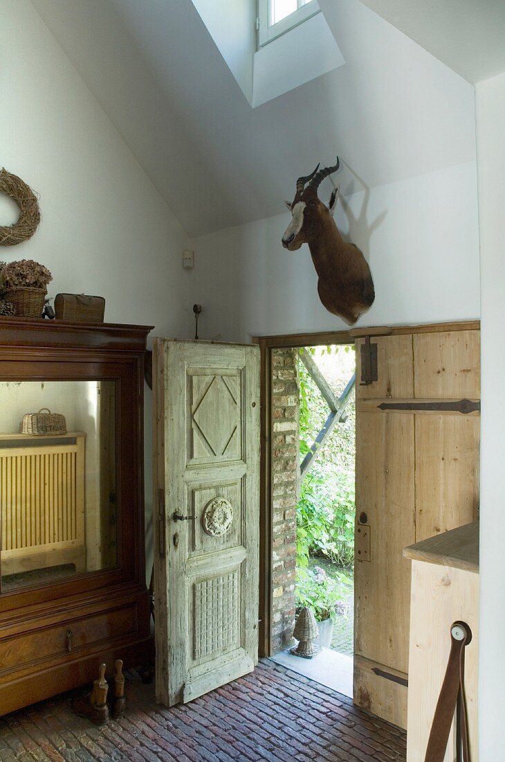 Renoviertes Landhaus mit antiker Holztür und Tiertrophäe