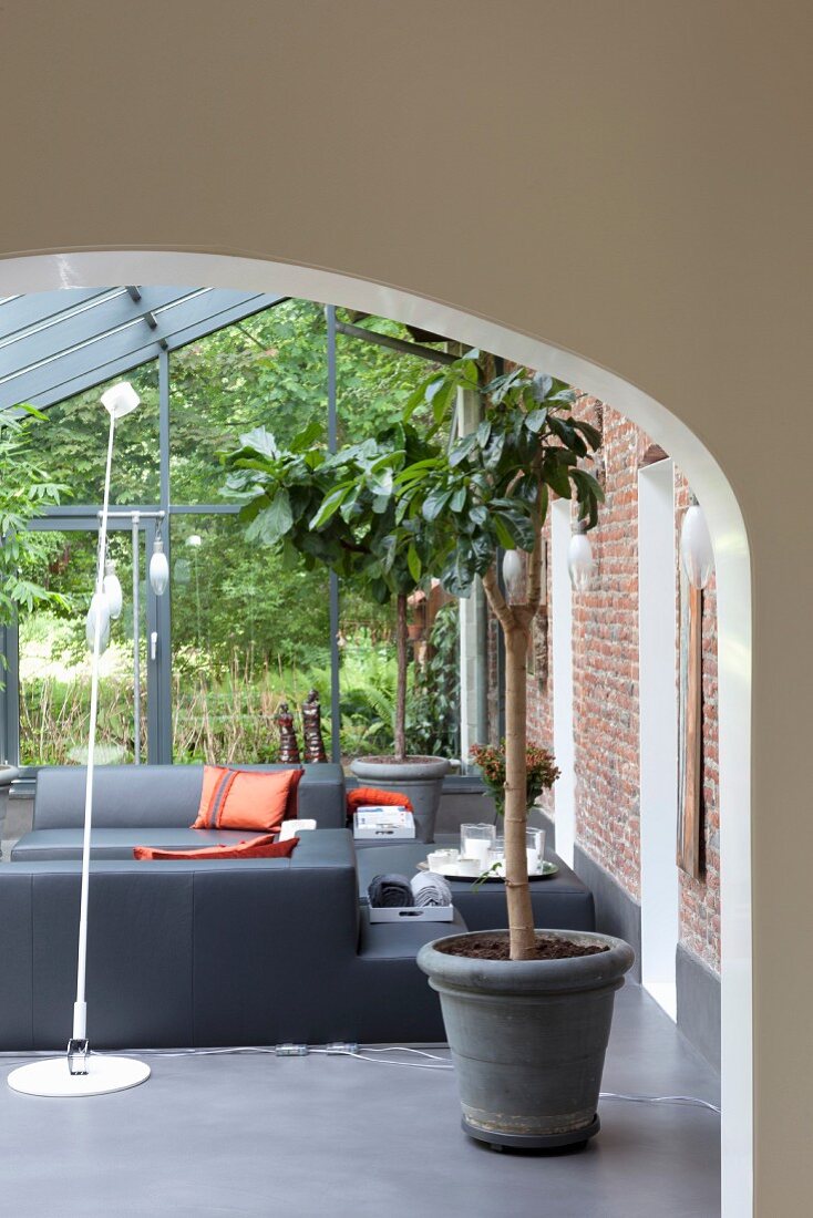 Lounge mit modernen, grauen Ledermöbeln in Wintergartenanbau