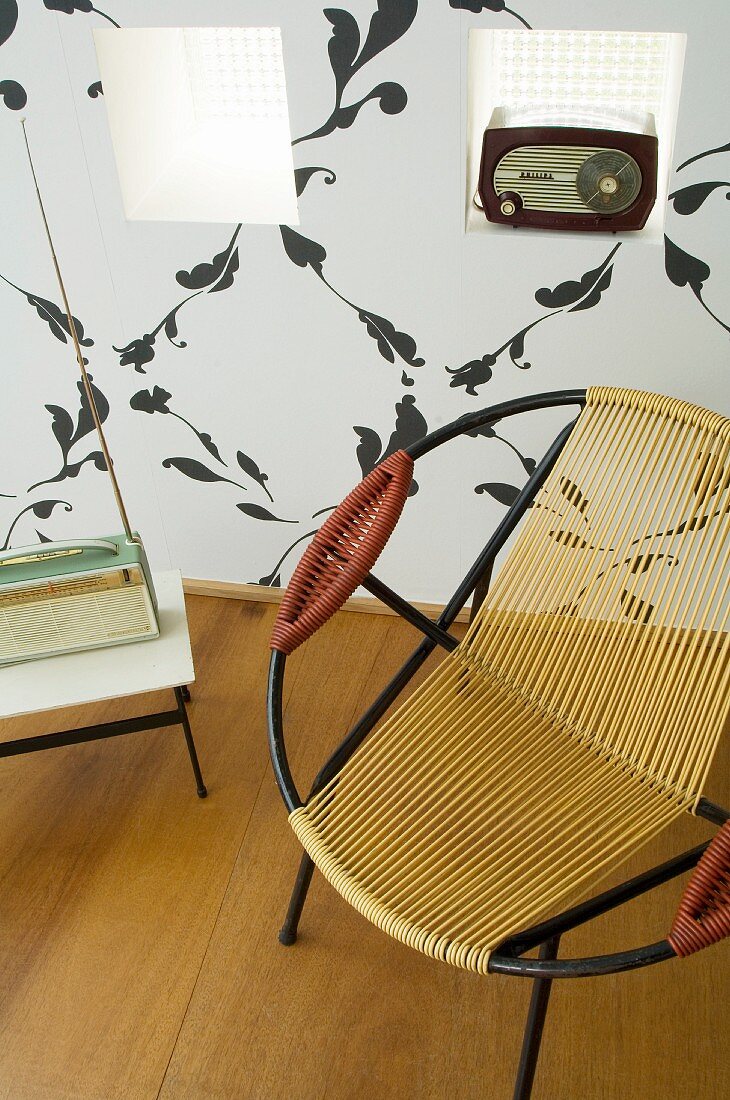 Retroradios und ein runder Sessel vor Wand mit Nischen