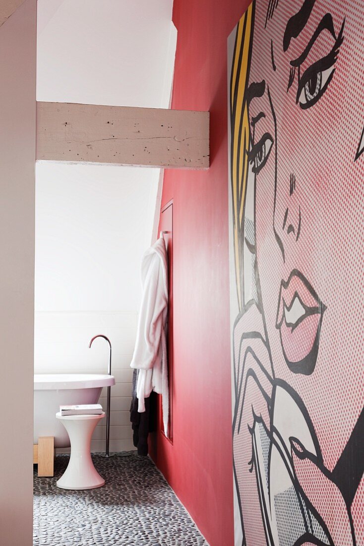 Bad Ensuite mit roter Wand und Kieselsteinboden, davor großformatiges Pop-Art Bild im Comicstil