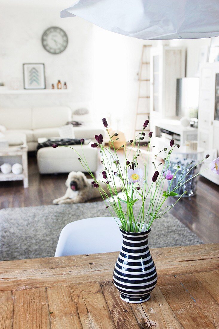 Black and white vase of wild flowers on rustic wooden table