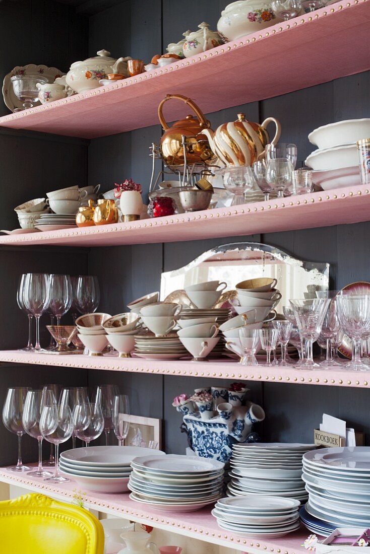 Crockery stacked on pink shelves