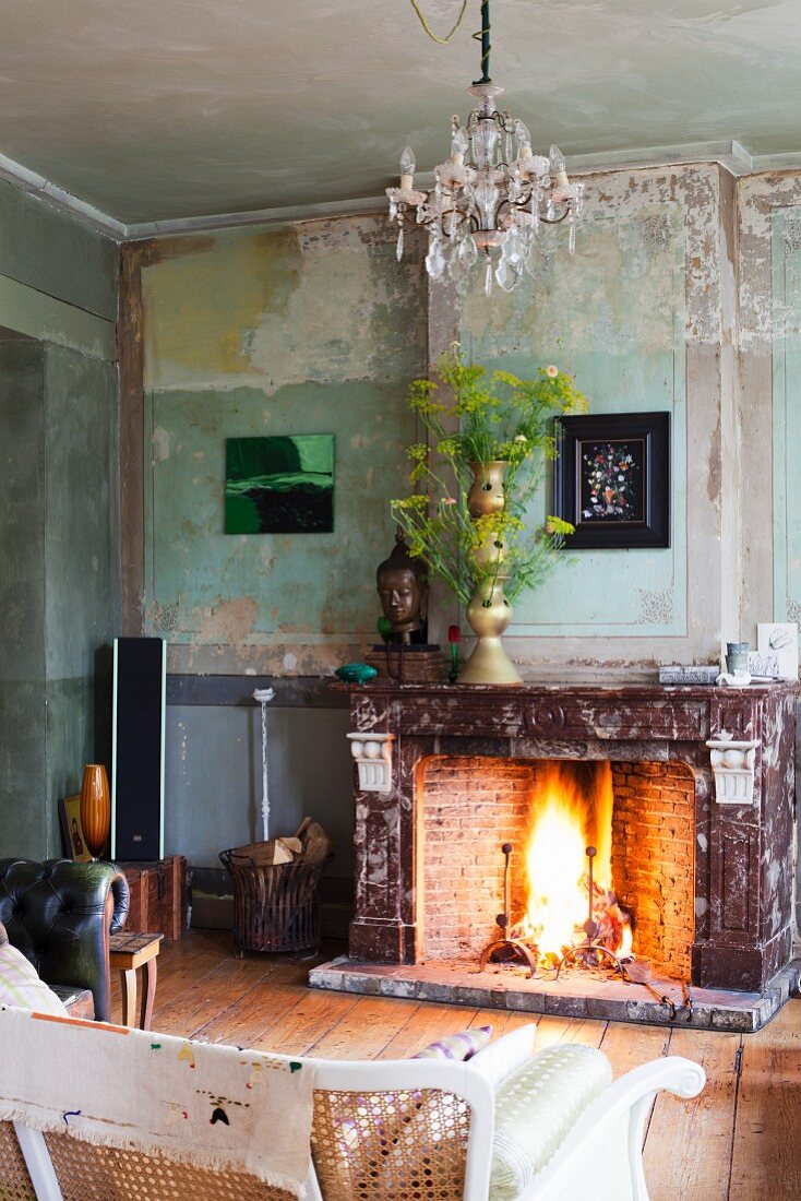 Kaminfeuer in Vintage Wohnraum mit Blumendeko