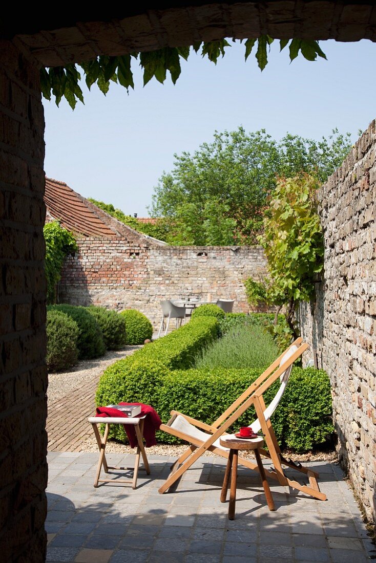 Box hedges and deckchair in courtyard garden