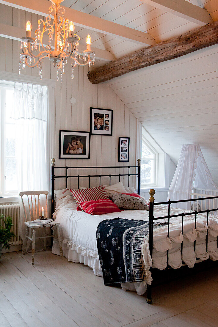 Bed with black metal frame in rustic attic bedroom