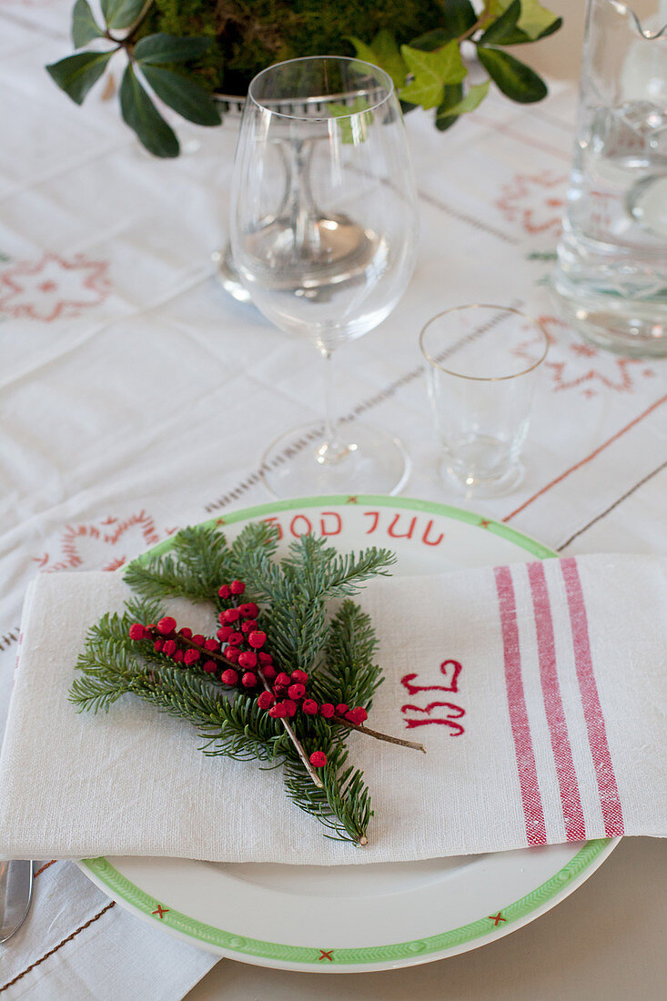 Table festively set with sprigs of fir and berries