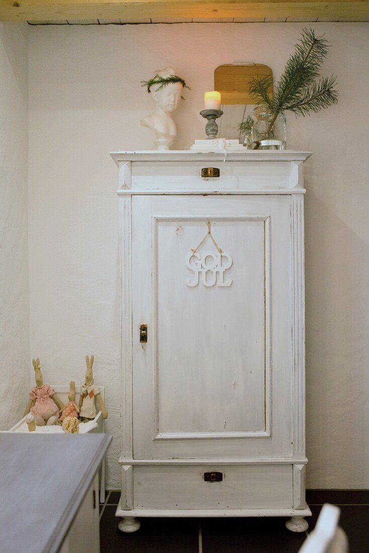 Nostalgischer Holzschrank, weiß gestrichen mit weihnachtlicher Deko